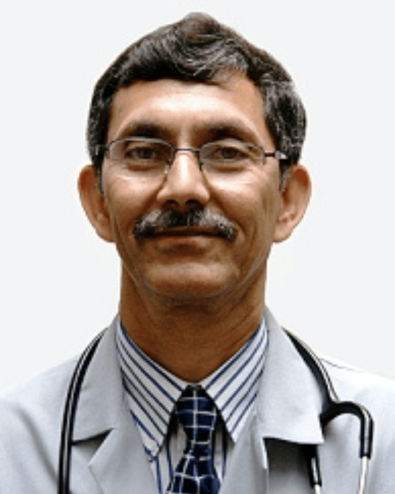 Portrait of a man with glasses and a mustache wearing a white medical coat and stethoscope, photographed against a plain background.